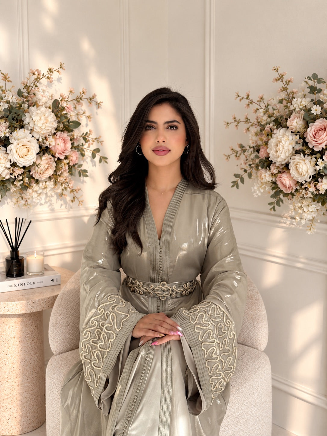 Model seated in taupe Takchita Sahar with a luminous finish and embroidered wide cuffs