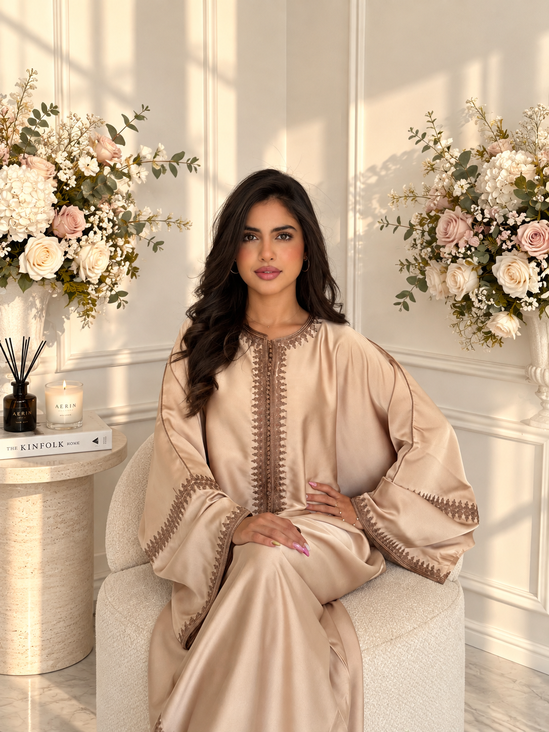 Model seated in champagne Gandoura Zaynab with contrasting brown embroidery along the neckline and sleeves