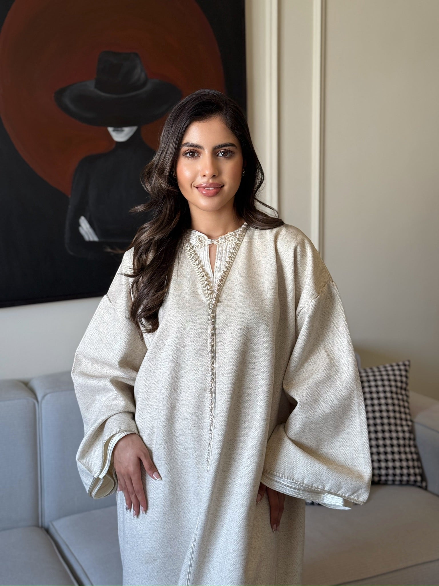 Woman wearing an ivory caftan with wide sleeves and elegant detailing