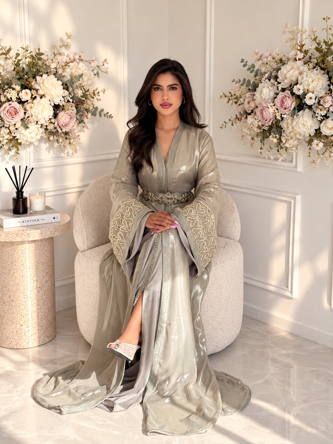 Full-length seated view of Takchita Sahar, a taupe two-piece Moroccan dress with a flowing silhouette