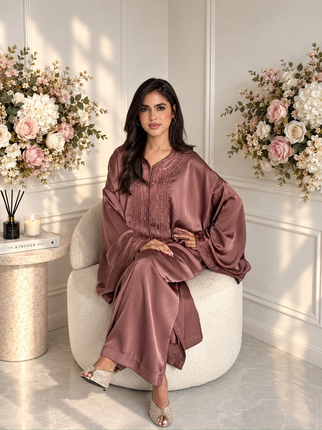 Full-length seated view of a model wearing mauve Moroccan Gandoura Laila with embroidered cuffs
