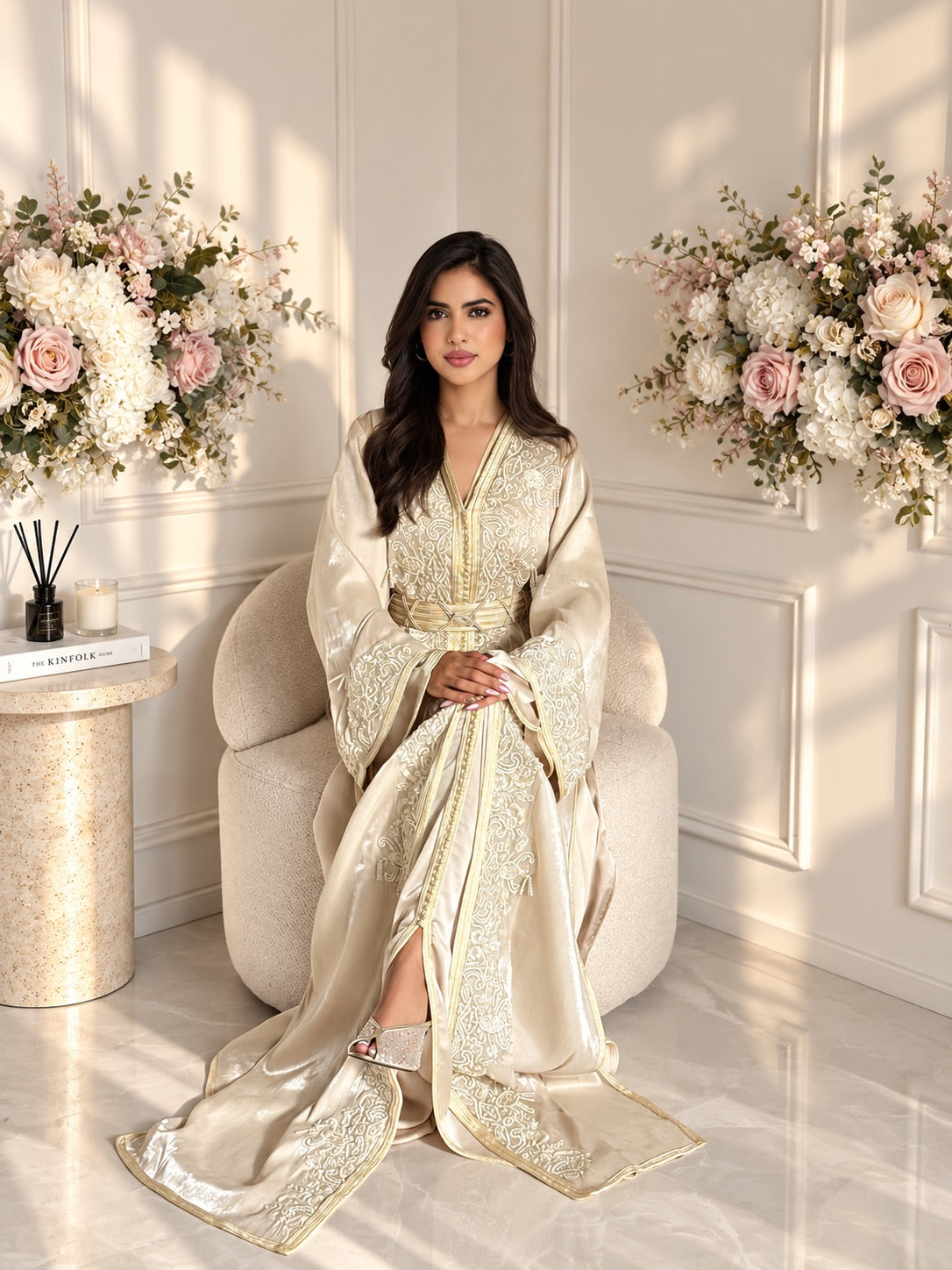 Full-length seated view of Takchita Mouna, a champagne two-piece Moroccan organza dress with gold-toned trim