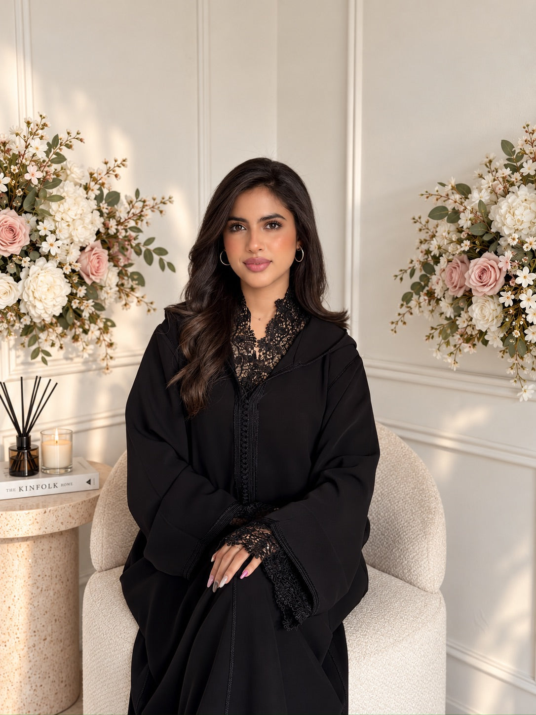 Model seated in black crepe Jellaba Meera with lace details at the neckline and cuffs