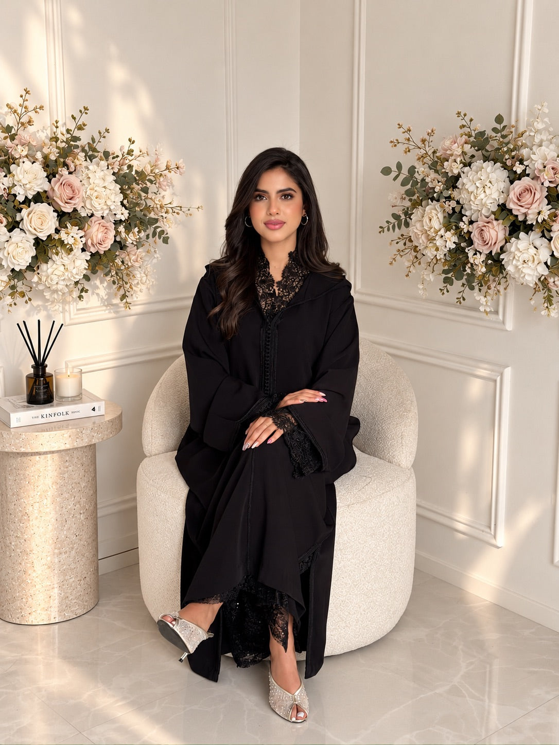 Full-length seated view of Jellaba Meera, a black two-piece Moroccan crepe jellaba