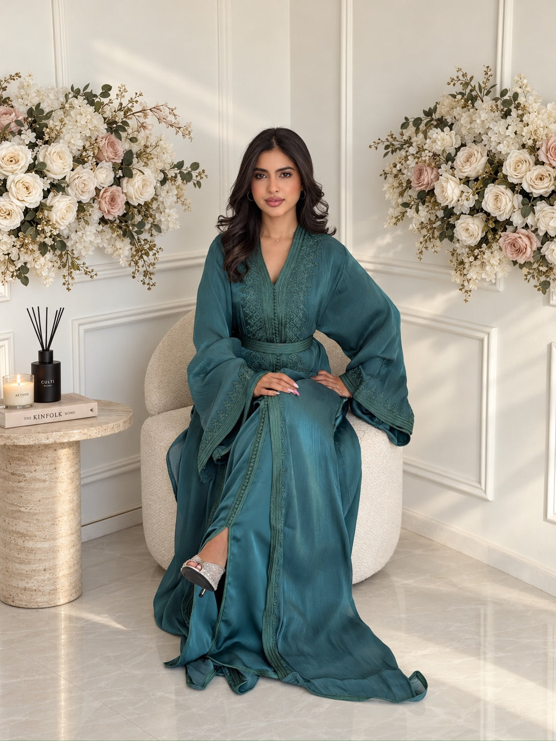 Full-length seated view of teal Moroccan Takchita Hanae with a matching belt and flowing skirt