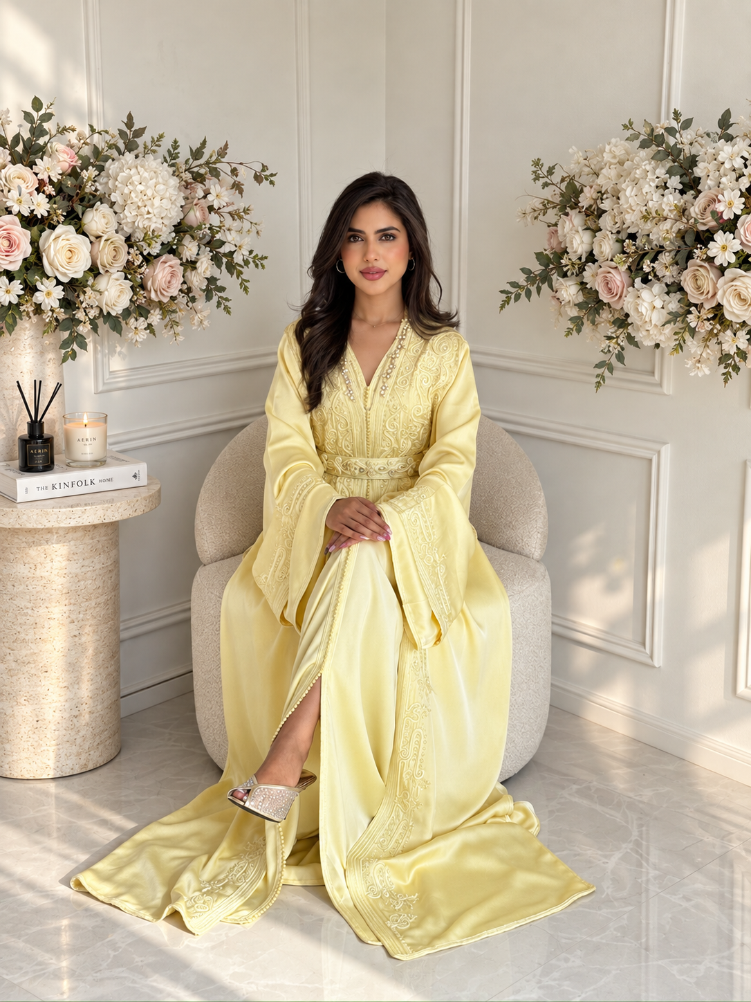 Full-length seated view of pale yellow Moroccan Takchita Mayssa with a flowing skirt and embroidered front